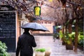 An adult man walked down the street of a city with a black umbrella on a rainy day Royalty Free Stock Photo