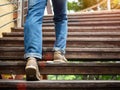 Adult man walking up the wooden stairs. Moving forward Concept.