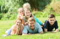 Adult man and woman with kids lying in park