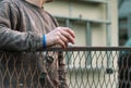 Adult man in working outfit is holding short drink full of vodka and waiting on neighbour. Drinking with friend across fence. Royalty Free Stock Photo