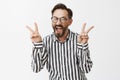 Adult mature guy never hide he is anime fan. Joyful carefree immature male model with beard in striped shirt, showing Royalty Free Stock Photo