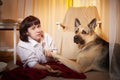 Adult mature woman with big shepherd dog in white shirt. Room with girl and calm cozy evening atmosphere with Royalty Free Stock Photo