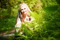 Adult mature woman 40-60 in a green long fairy dress in forest. Photo shoot in style of dryad and queen of nature. Fairy