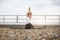 Adult meditating in pose with twisted legs on gravel roof Royalty Free Stock Photo