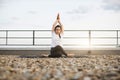 Adult meditating in pose with twisted legs on gravel roof Royalty Free Stock Photo