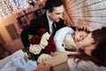 Adult man with roses bouquet is put to bed small daughter to sleep. Child is sleeping. Royalty Free Stock Photo