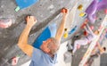 Adult man practicing rock climbing on climbing wall Royalty Free Stock Photo