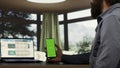 Adult millionaire looks at greenscreen smartphone display