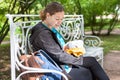 Adult mother looking at her eating baby, breast feeding on the street, woman sitting on the bench Royalty Free Stock Photo