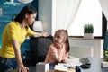 Adult mother watching little girl doing schoolwork Royalty Free Stock Photo