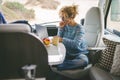 Adult nice woman work on laptop sitting in a camper van dinette enjoying freedom travel vacation or vanlife lifestyle. Modern job Royalty Free Stock Photo