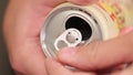 Adult opens holds in his hand a cold aluminum can of carbonated drink with drops of water and opens the lid with his