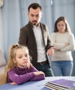 Adult parents lecturing girl for bad behavior