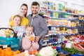 Adult parents with two girls choosing fruits