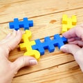 adult person plays with yellow and blue puzzzles