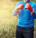 Adult plump athlete in blue uniform and red leather boxing gloves Royalty Free Stock Photo