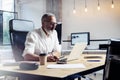 Adult professional businessman wearing a classic glasses and working at the wood table in modern coworking studio Royalty Free Stock Photo