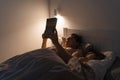 Adult reading a book in bed with child at night Royalty Free Stock Photo