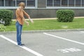 An adult red-haired woman gestures with both hands to an empty parking space. Royalty Free Stock Photo