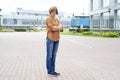 An adult redhead woman in casual clothes stands in the street with her arms crossed in annoyance. Royalty Free Stock Photo