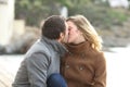 Adult couple in love kissing on the beach in winter Royalty Free Stock Photo