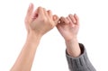 An adult and a child are making a pinky promise / pinkie swear, isolated with white background