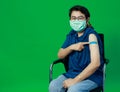 Adult senior Asian woman wearing hygiene mask confident show shoulder with bandage plaster after getting Coronavirus of Covid-19 Royalty Free Stock Photo