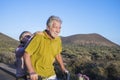 Adult senior caucasian couple go bike smiling and having a lot of fun together, vacation or alternative retired lifestyle make