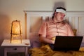 Adult sick man sleeping tiredly lying on bed with computer Royalty Free Stock Photo