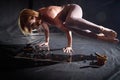 An adult skinny blonde woman doing yoga exercises on a black background in the studio. Sporty girl model posing in a Royalty Free Stock Photo