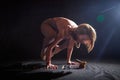 An adult skinny blonde woman doing yoga exercises on a black background in the studio. Sporty girl model posing in a Royalty Free Stock Photo