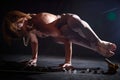 An adult skinny blonde woman doing yoga exercises on a black background in the studio. Sporty girl model posing in a Royalty Free Stock Photo