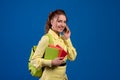 Adult smiling brunette woman taking notes in daily book and talking on mobile phones