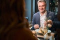 Adult smiling caucasian man and cropped woman eating pasta in hotel restaurant Royalty Free Stock Photo