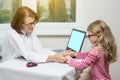 Adult smiling female doctor and her little patient. Child and doctor are holding hands. Royalty Free Stock Photo