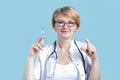 Adult smiling woman doctor with stethoscope holds syringe, ampoule Royalty Free Stock Photo