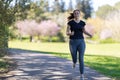 An adult smiling woman jogging on nature Royalty Free Stock Photo