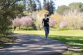 An adult smiling woman in tight leggings jogging on nature Royalty Free Stock Photo