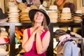 Adult smiling woman try on boater hat in shopping mall Royalty Free Stock Photo