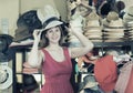 Adult smiling woman try on boater hat in shopping mall Royalty Free Stock Photo