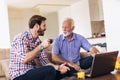 Adult Son Helping Senior Father With Computer