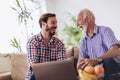 Adult Son Helping Senior Father With Computer