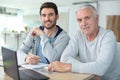 adult son helping senior father with computer at home Royalty Free Stock Photo