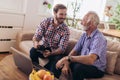 Adult Son Helping Senior Father With Computer