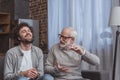 adult son and senior father talking and laughing