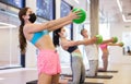 Adult sports people in protective masks performs an exercise, holding a mini Pilates ball in front of them Royalty Free Stock Photo