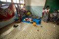 an adult stands next to two children and a baby in a room with other people