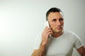 Adult strict man talking on the phone He is angry and a little dissatisfied with the conversation Studio all white phone