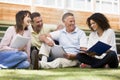 Adult students sitting on a campus lawn