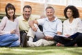 Adult students sitting on a campus lawn